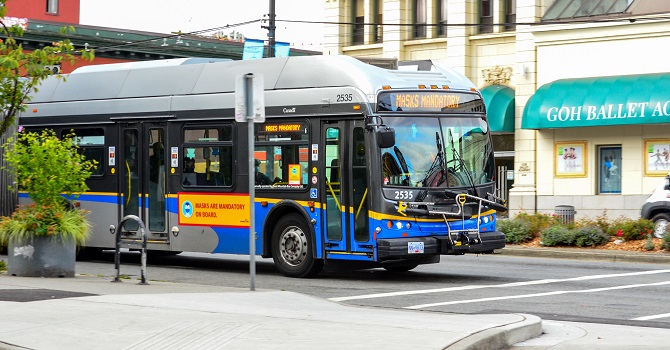 The busses are the core of the transit system in Vancouver. Pictured is a bus across a building.